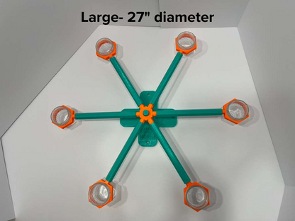 Large 27-inch scent wheel with bright orange scent cup holders and rotating spinners on a sturdy teal base and arms, built for professional detection dogs, AKC scent work trials, etc. scent cup holders have 4 oz glass jars for target odor. Photo for size, note of wheel for sale.