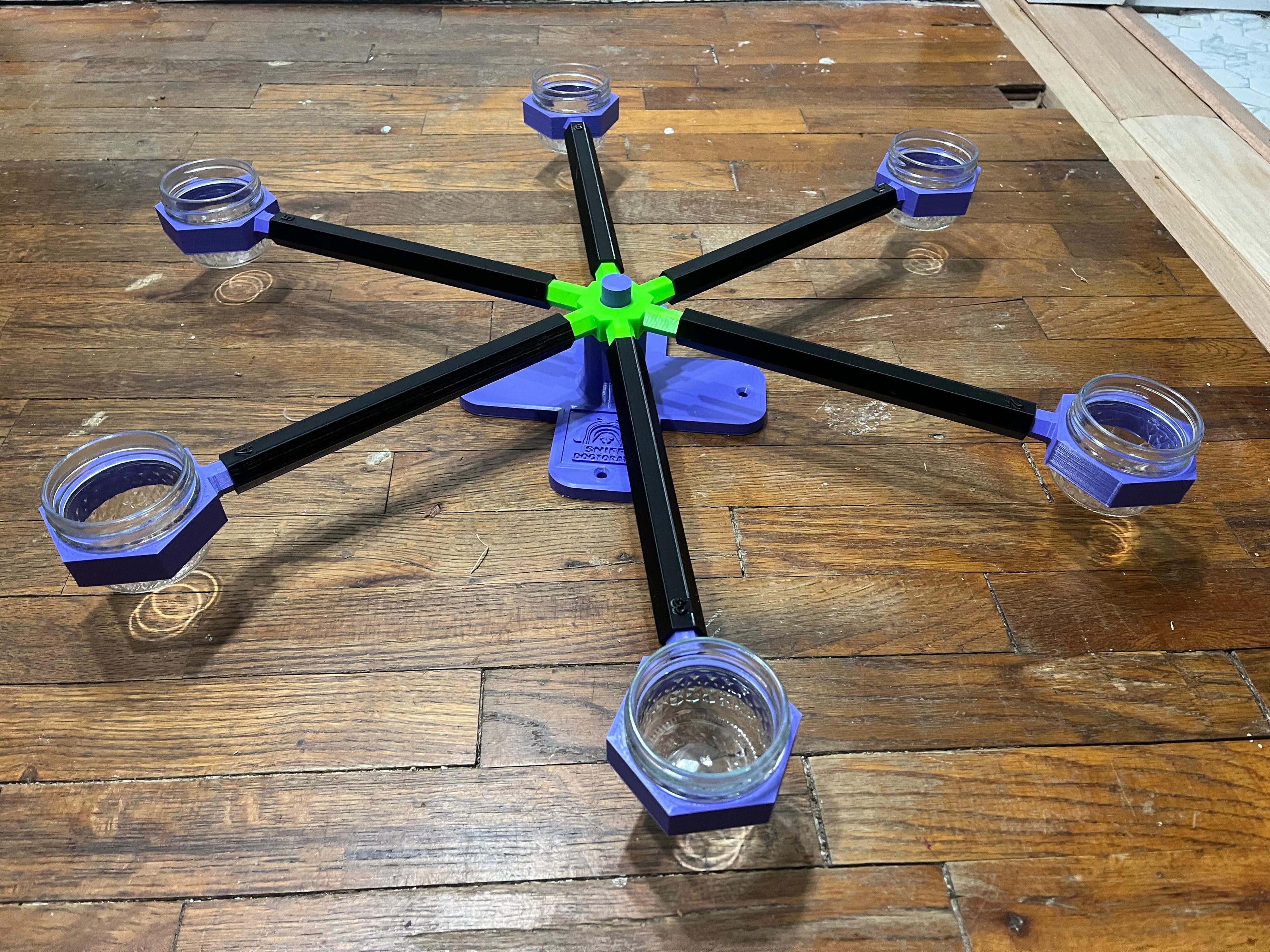 Large wheel with purple cups, black arms, a green spinner, and a purple base