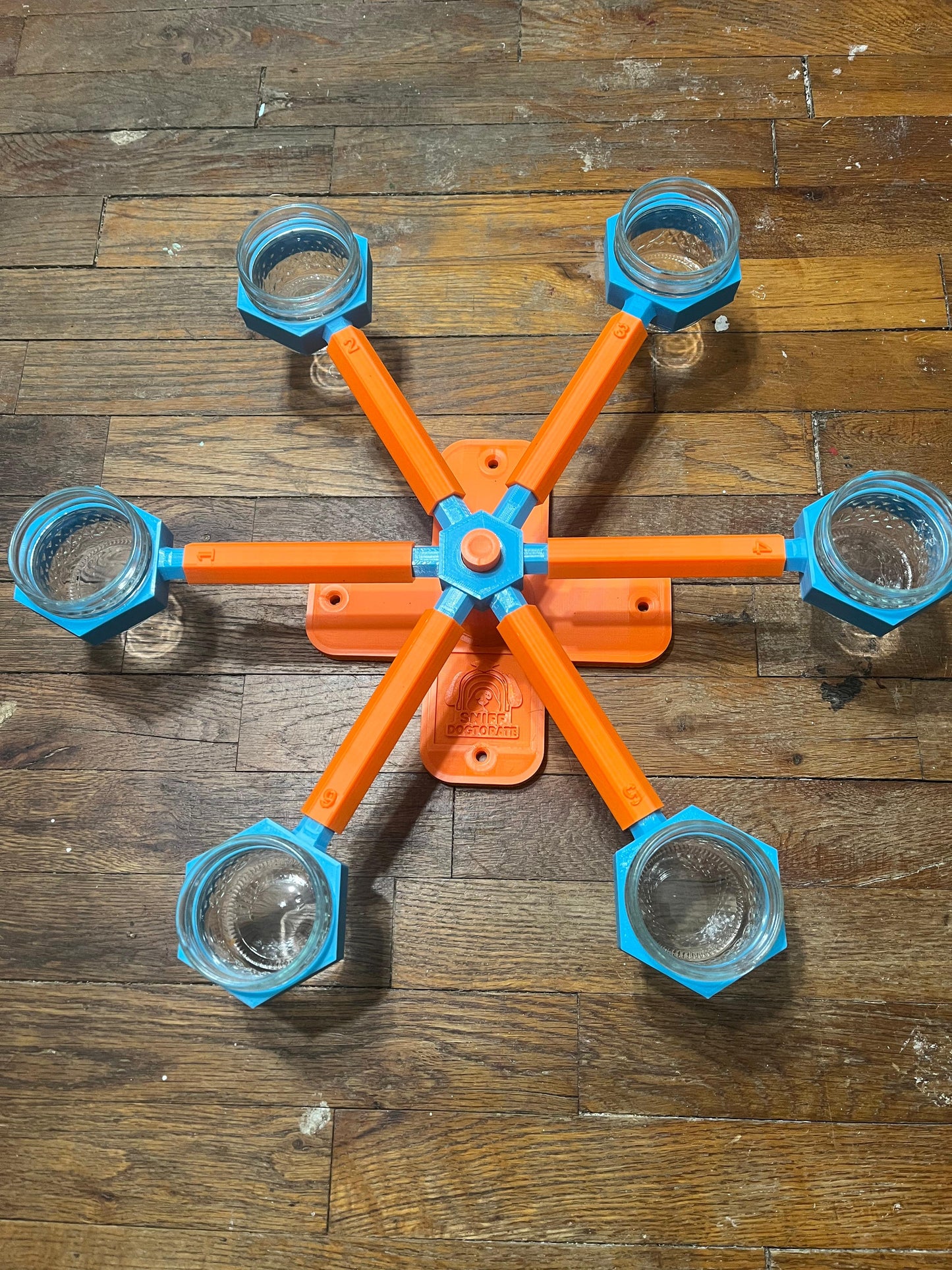 Orange and blue small scent wheel, shown assembled. Diameter is 19" and height is 2.5". There are holes in the base to use decking screws to mount wheel higher