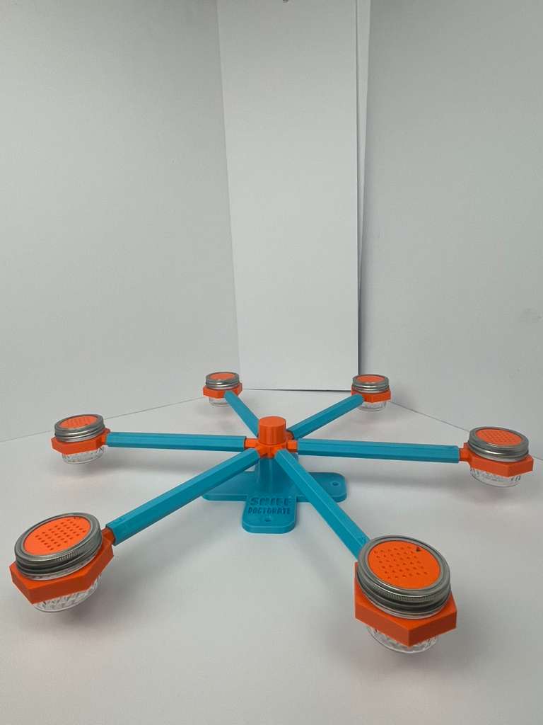 Large scent wheel with sky blue base and arms, sunny orange spinner, topper, cup covers, and cup holders