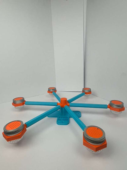 Large scent wheel with sky blue base and arms, sunny orange spinner, topper, cup covers, and cup holders