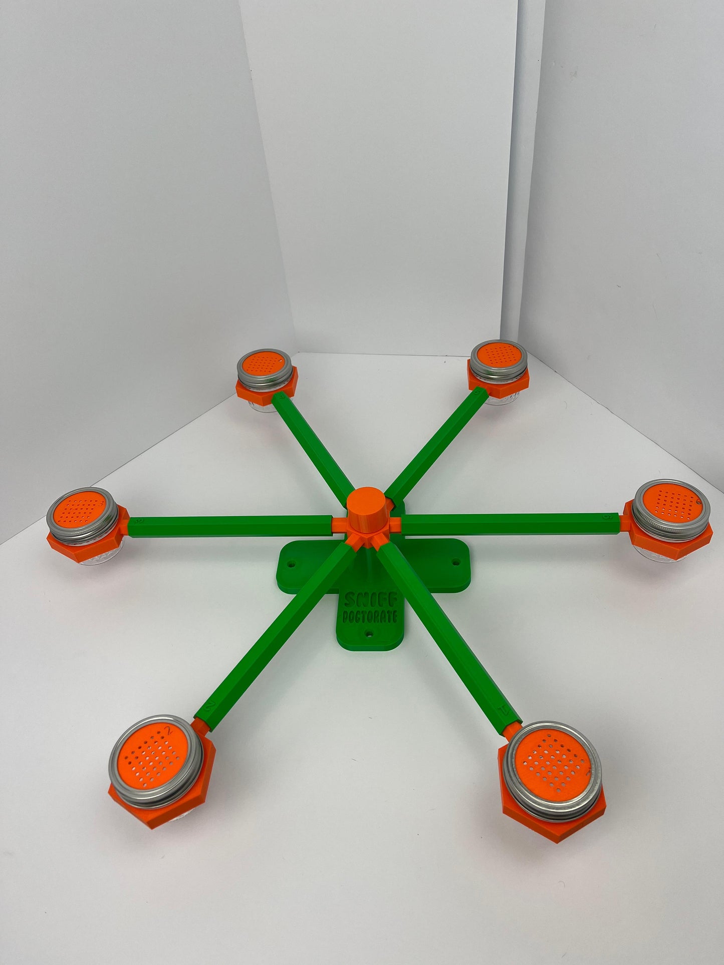 Large scent wheel with green base and arms, sunny orange spinner, topper, cup covers, and cup holders