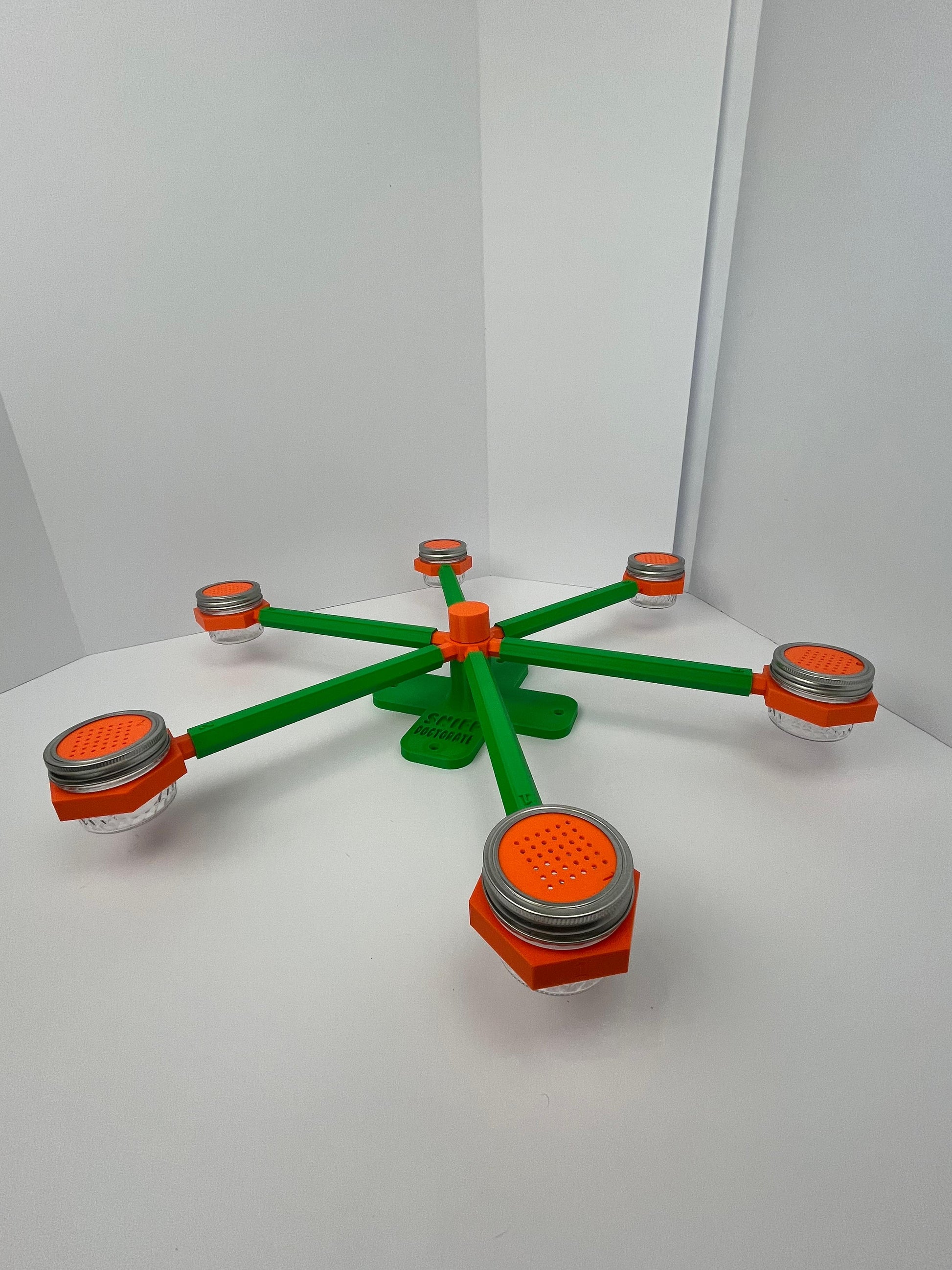 Large scent wheel with green base and arms, sunny orange spinner, topper, cup covers, and cup holders