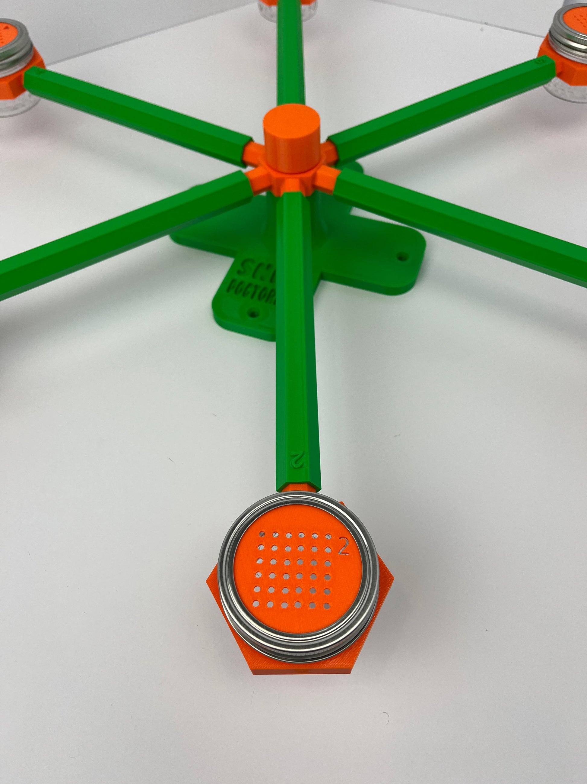 Large scent wheel with green base and arms, sunny orange spinner, topper, cup covers, and cup holders