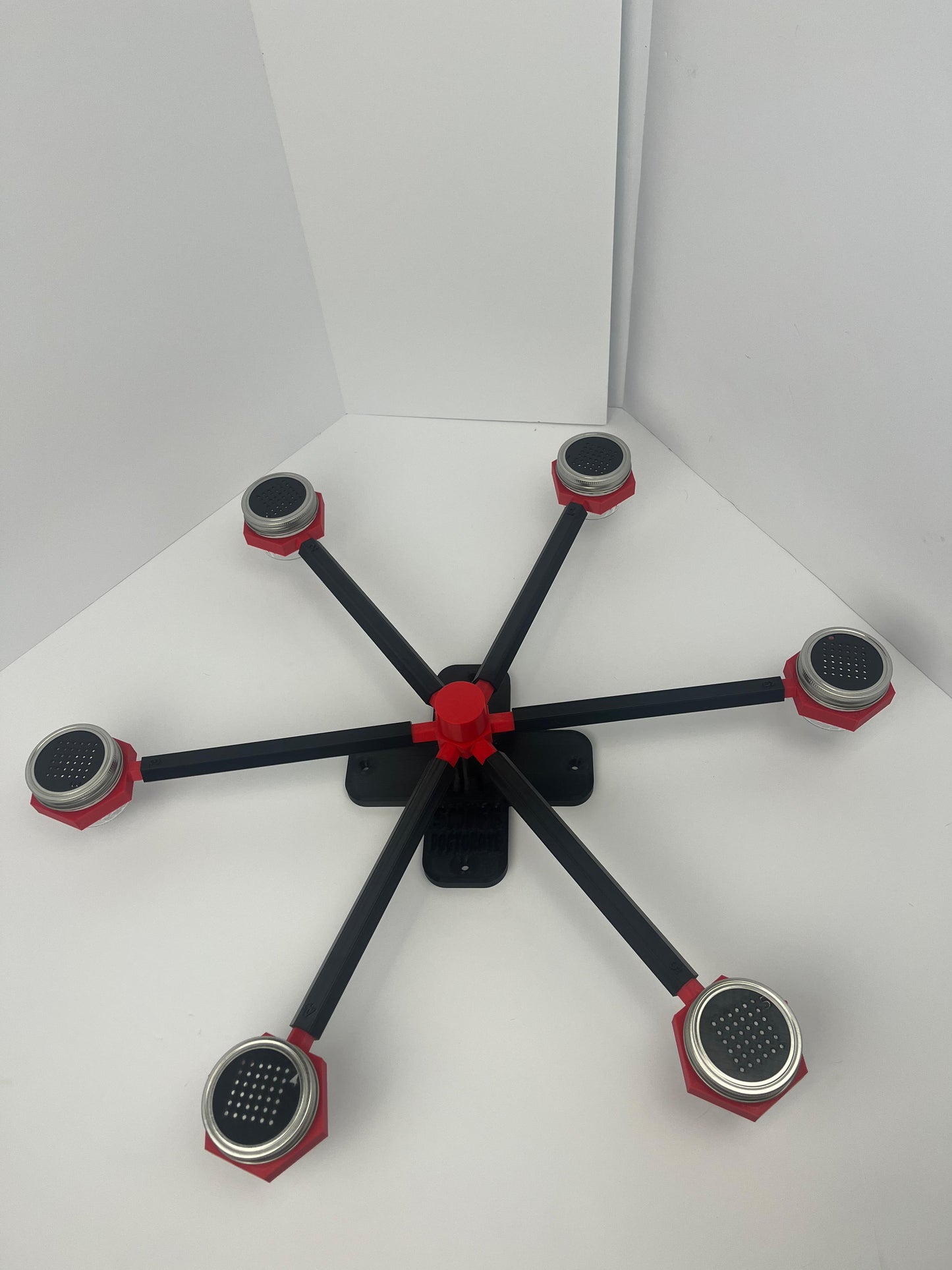 Large scent wheel with black base and arms, red spinner, topper, cup covers, and cup holders