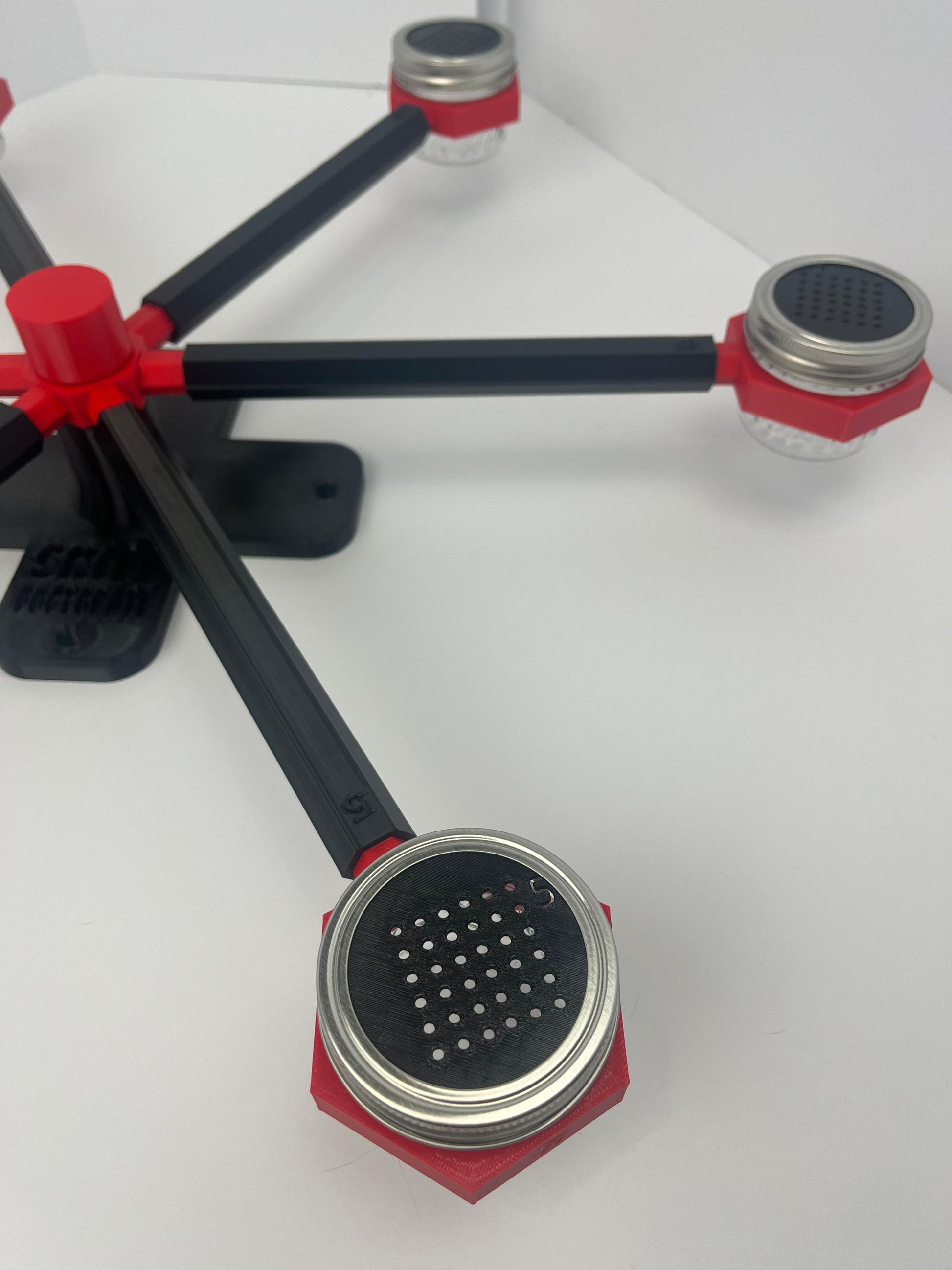 Large scent wheel with black base and arms, red spinner, topper, cup covers, and cup holders