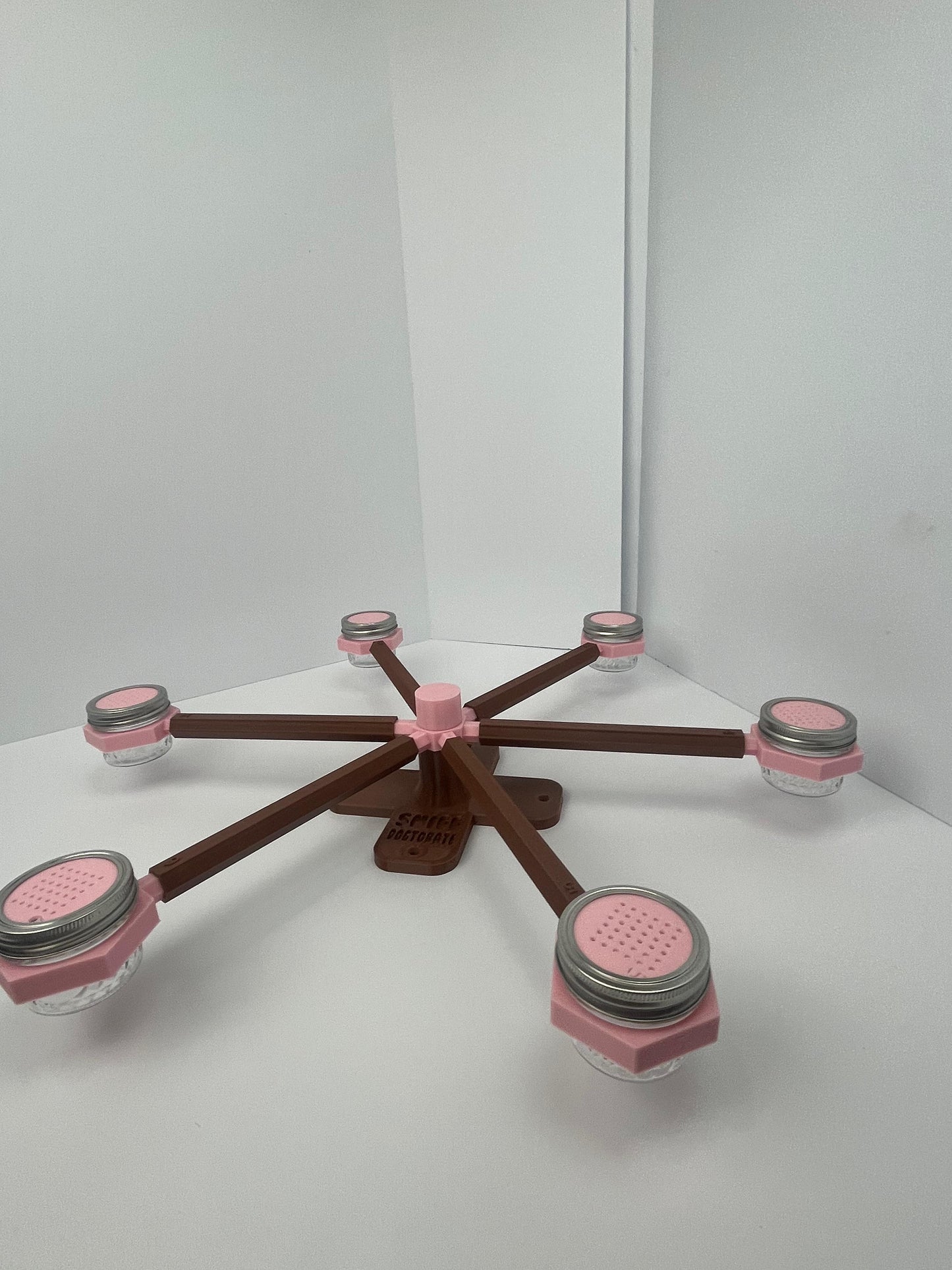 Large scent wheel with chocolate brown base and arms and sakura pink spinner, cup holders, cup covers, and base topper