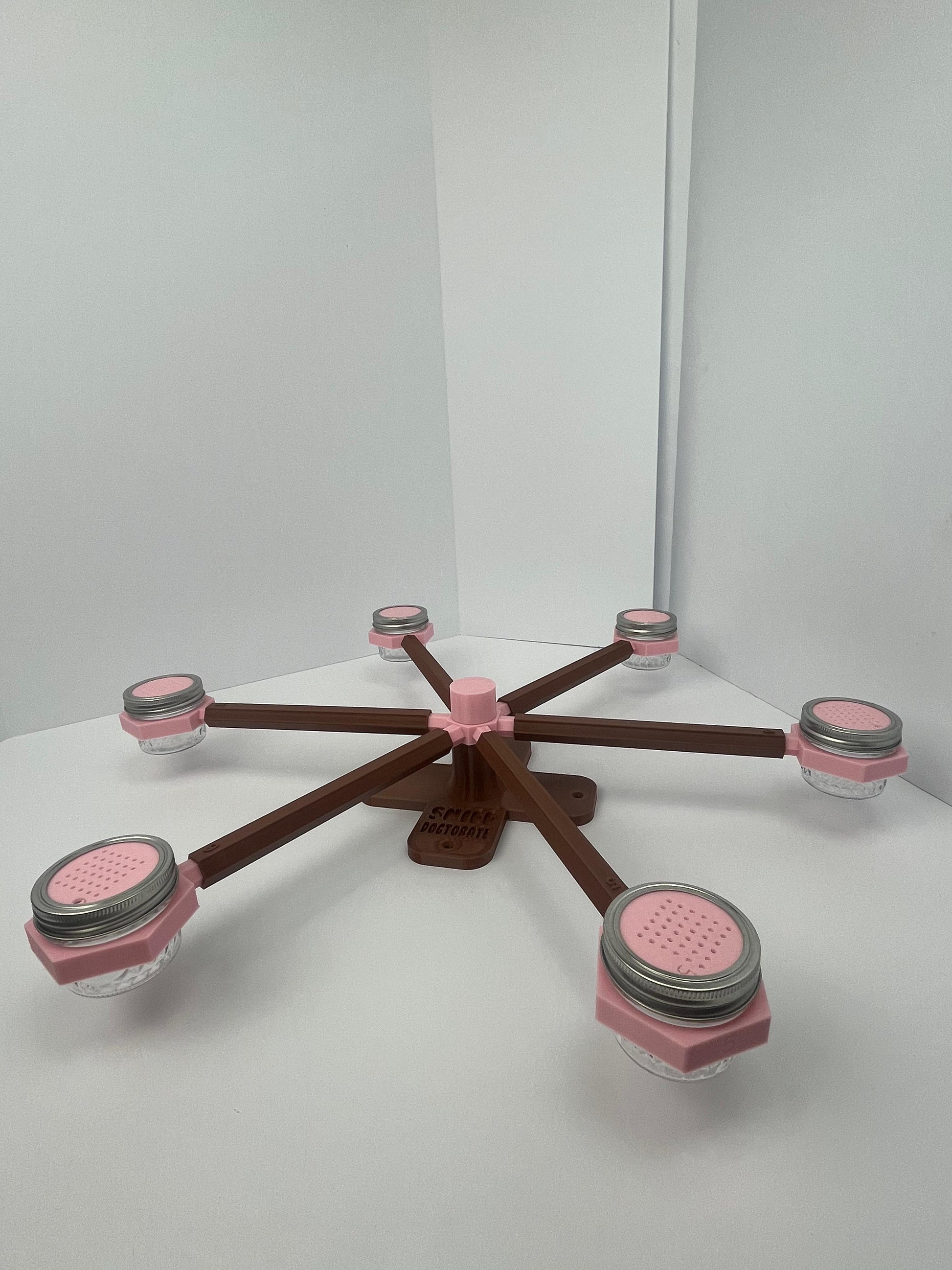 Large scent wheel with chocolate brown base and arms and sakura pink spinner, cup holders, cup covers, and base topper