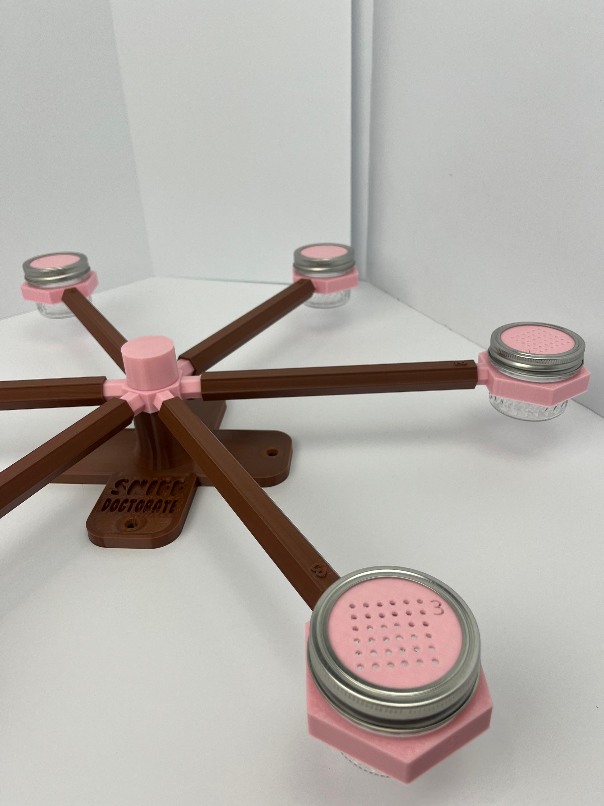 Large scent wheel with chocolate brown base and arms and sakura pink spinner, cup holders, cup covers, and base topper