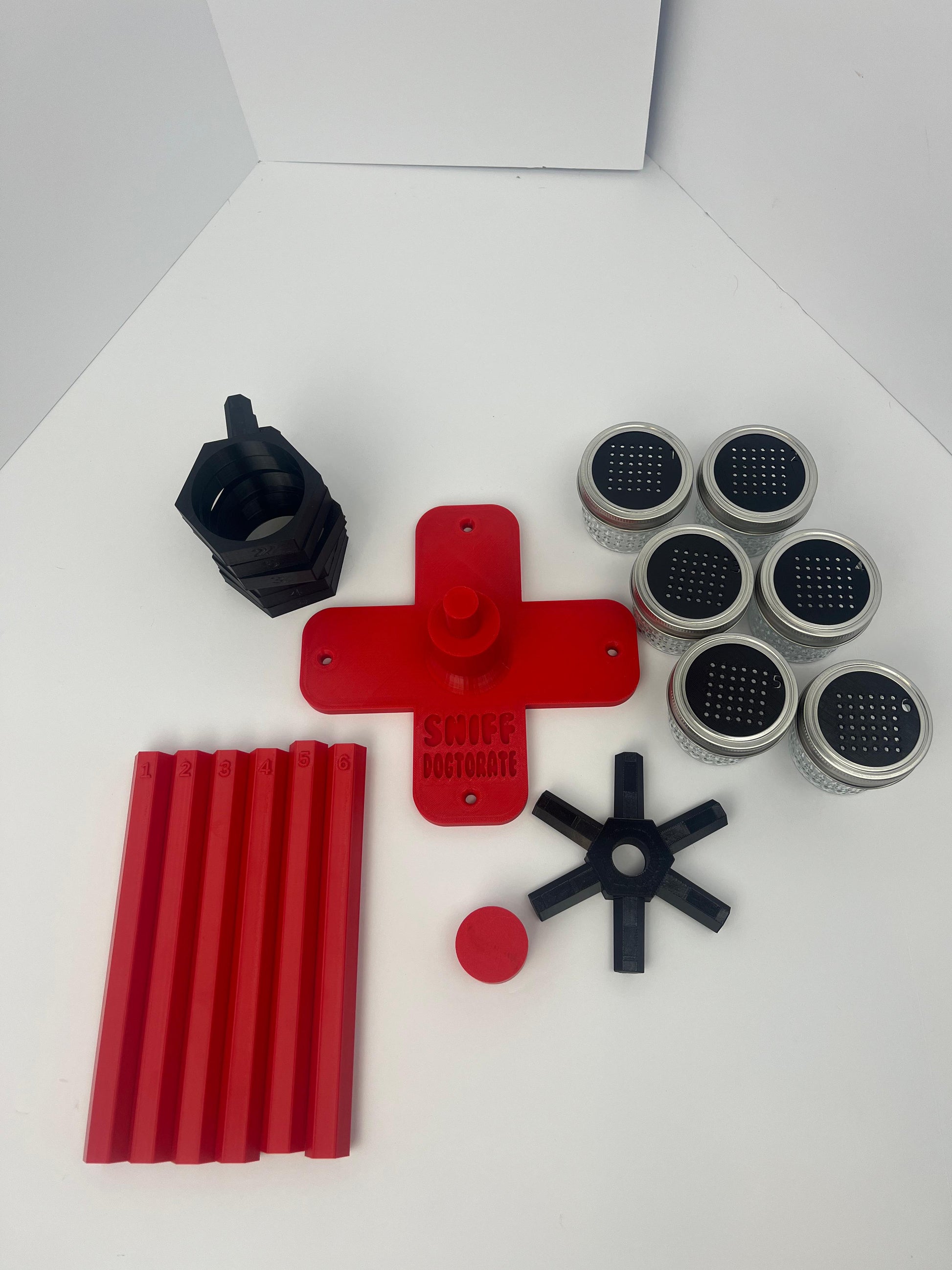 Large scent wheel with red base and arms and black spinner, cup holders, cup covers, and base topper
