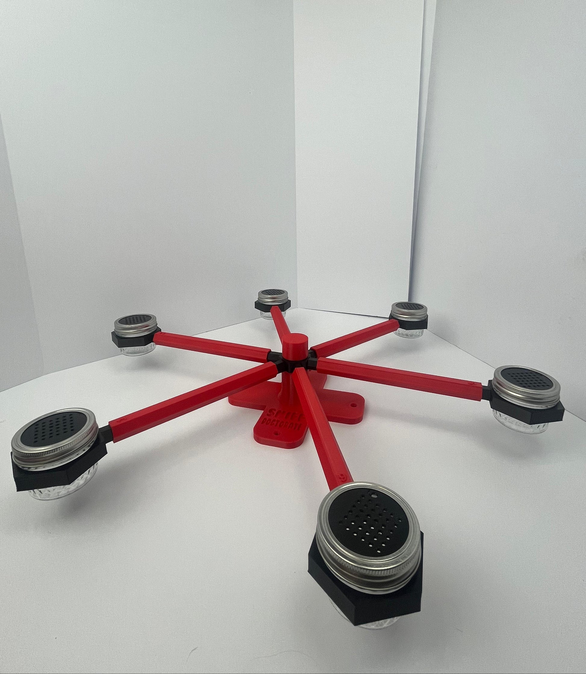 Large scent wheel with red base and arms and black spinner, cup holders, cup covers, and base topper