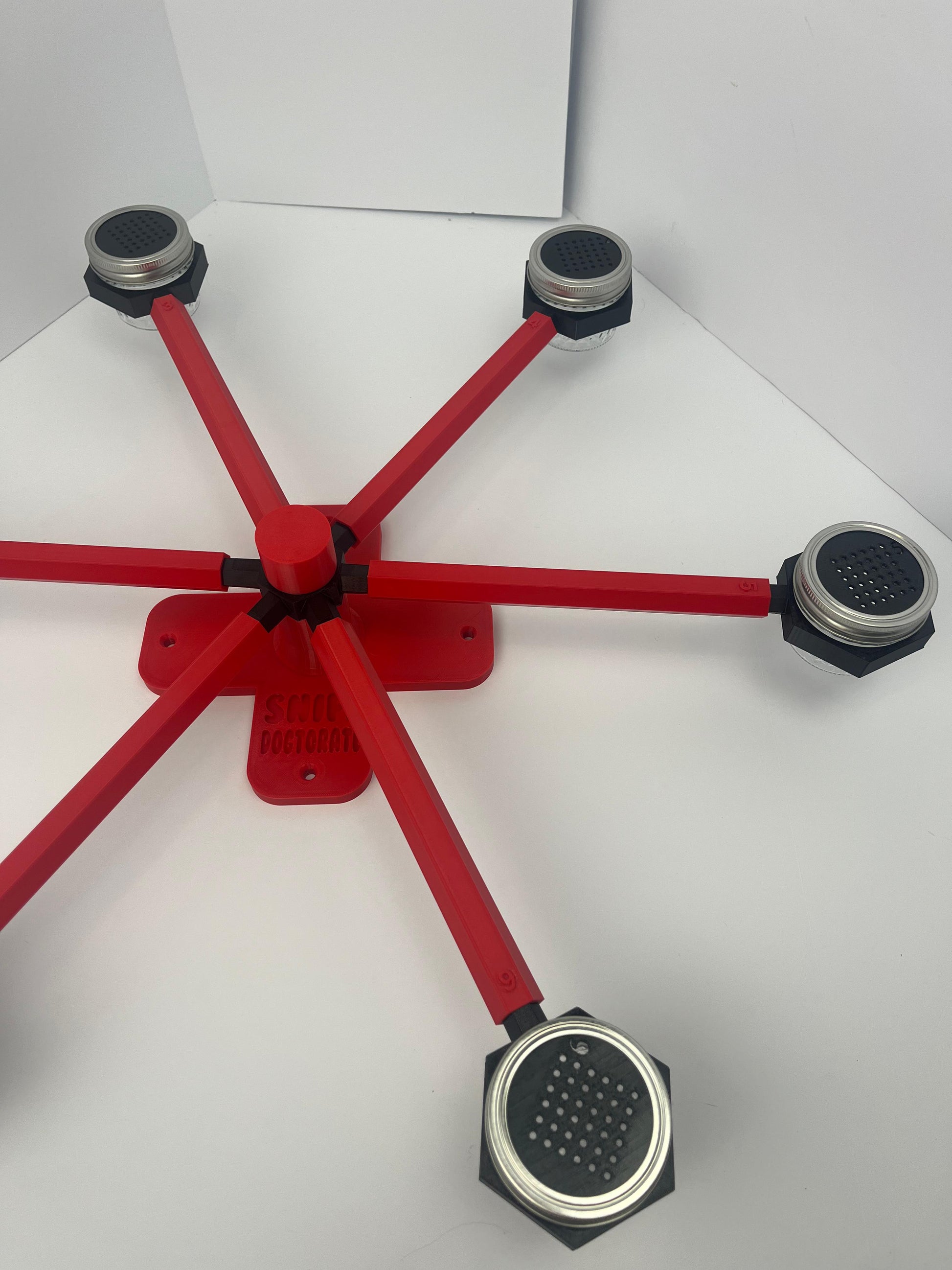 Large scent wheel with red base and arms and black spinner, cup holders, cup covers, and base topper