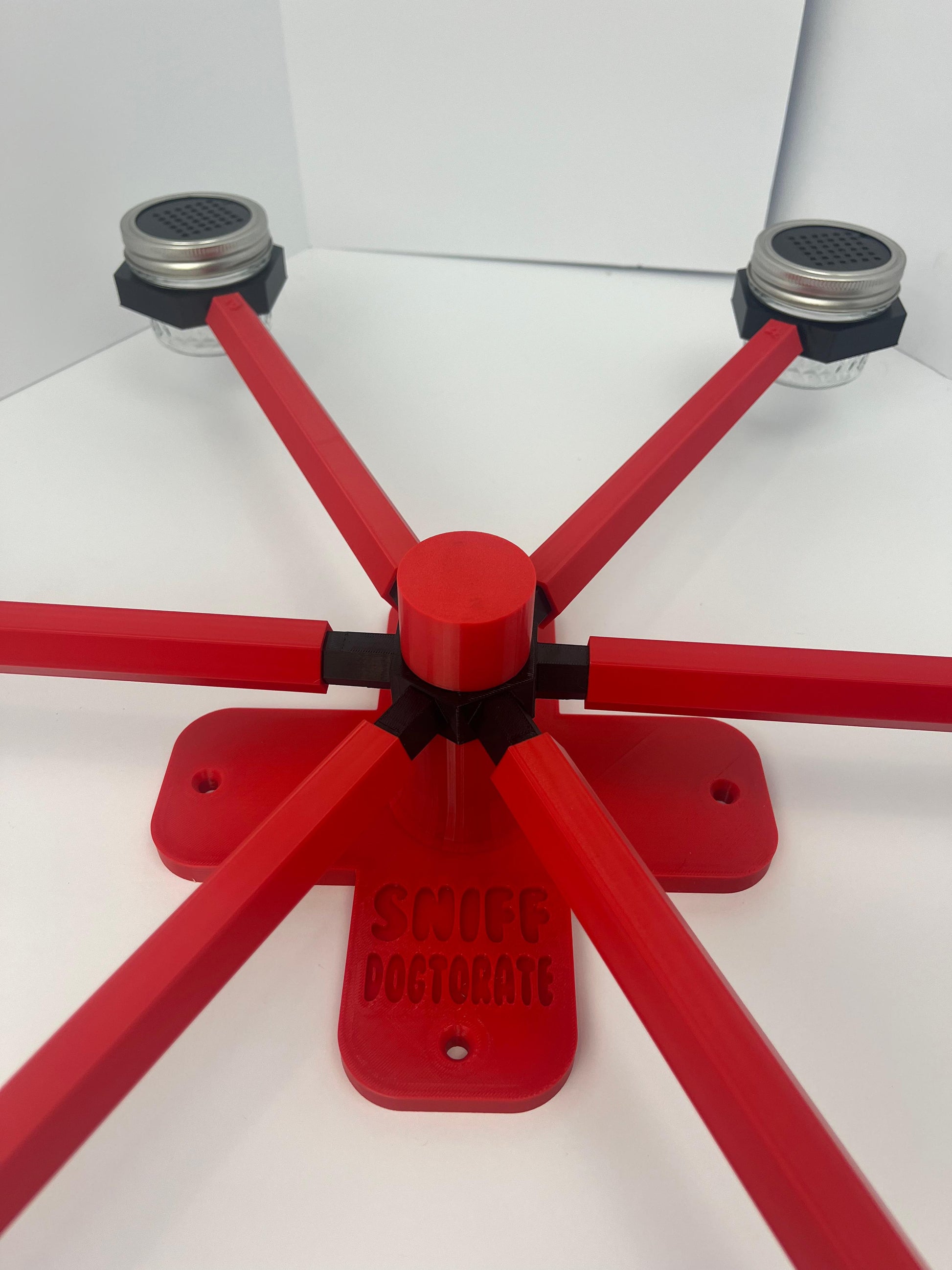 Large scent wheel with red base and arms and black spinner, cup holders, cup covers, and base topper